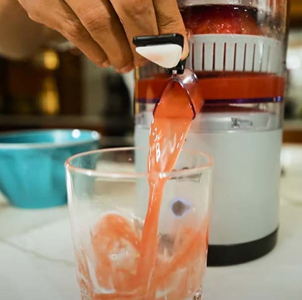 Imagen de máquina exprimidora Huugo sirviendo el jugo exprimido en un vaso