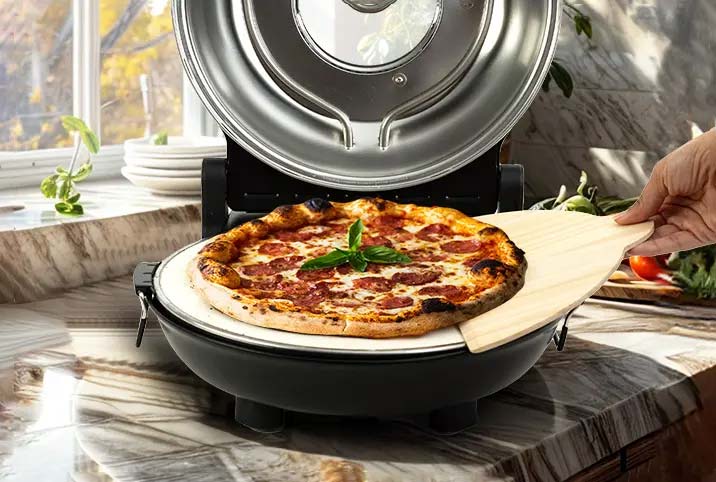 Imagen de una persona sirviendo un trozo de pizza hecho con el horno Pizano